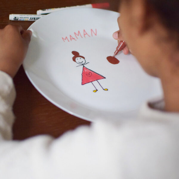 fille qui dessinne sur une assiette