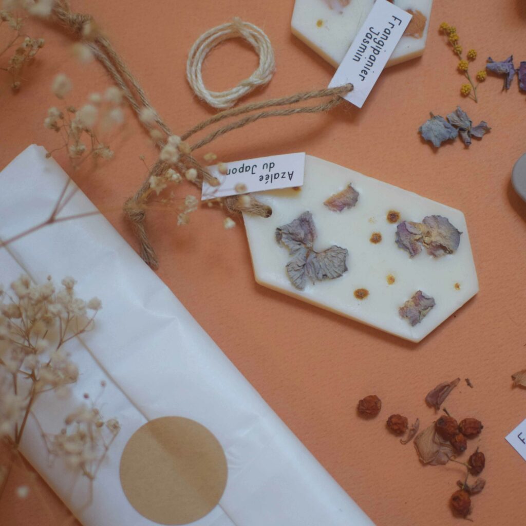 Kit DIY suspension parfumée avec moule en silicone, fleurs séchées, cire végétale, parfum de Grasse et étiquettes, sur fond terracotta.
