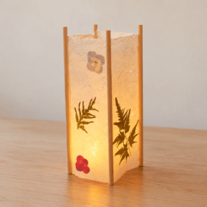 Lampe Japandi en bois et papier de riz, décorée de fleurs et de fougères pressées, éclairée par une bougie LED.